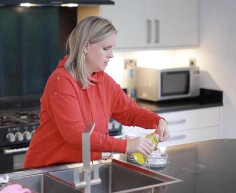 Mixing a baking soda cleaning paste at the sink